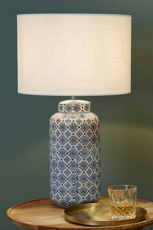 Large ceramic table lamp with blue detailed pattern over coffee table
