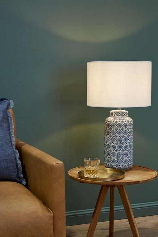 Large ceramic table lamp with blue detailed pattern over coffee table