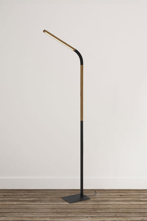 Black floor lamp with adjustable head and wood accents