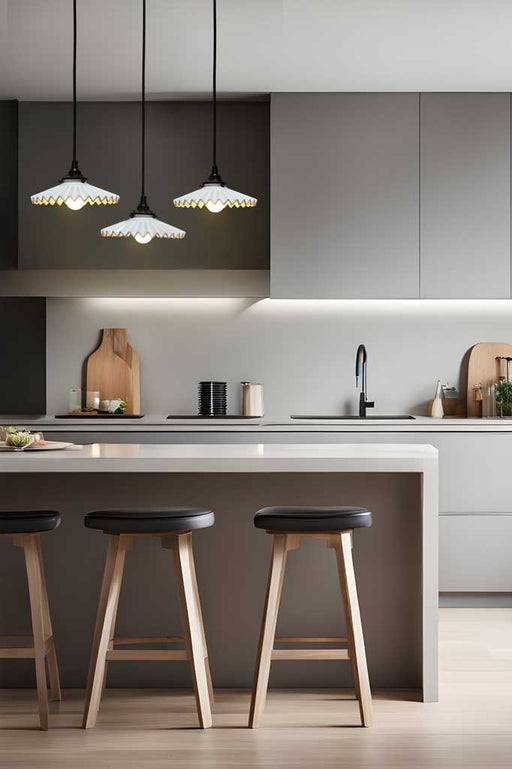 Three white ceramic Charmont pendants with black cords suspended over a modern kitchen bench. 