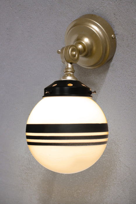 Gold brass wall light with black gallery and opal glass shade with three stripes