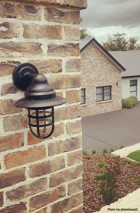 Black out door wall light hanging on a brick wall.