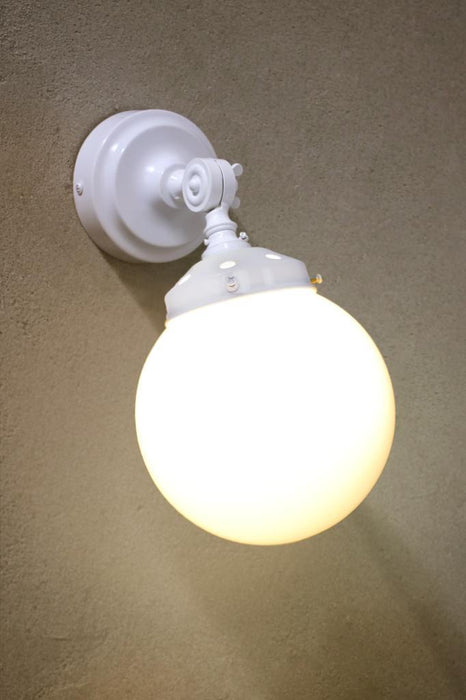 White wall light with white gallery and opal shade against a concrete background