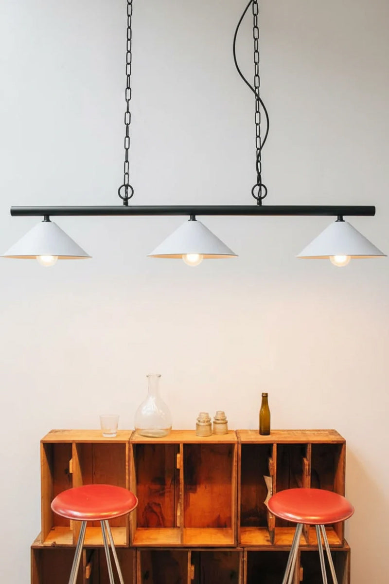 Black linear light fixture with white cone shades. 
