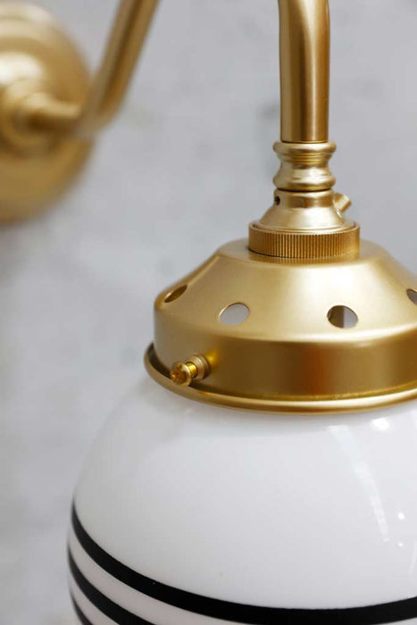 Glass ball wall light in satin brass finish close up