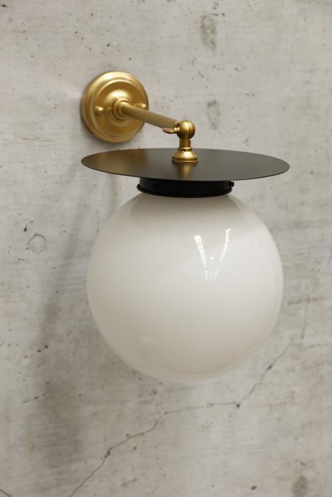 long gold brass arm with black disc and opal shade