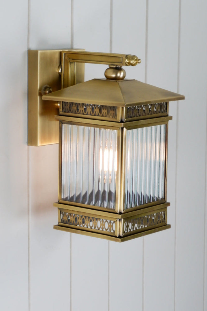 Small brass wall light with clear fluted glass. 