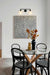 Black wall light with two holophane glass shades over a wall art in a dining room