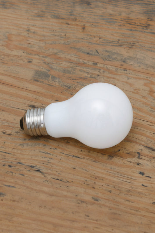 Two 6W E27 LED A60 Round 2200K Opal Bulbs placed on a timber bench. 