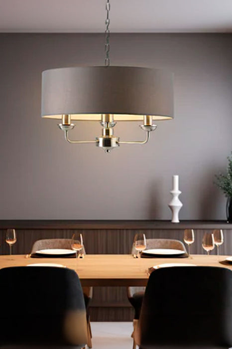 small grey chandelier above dining table