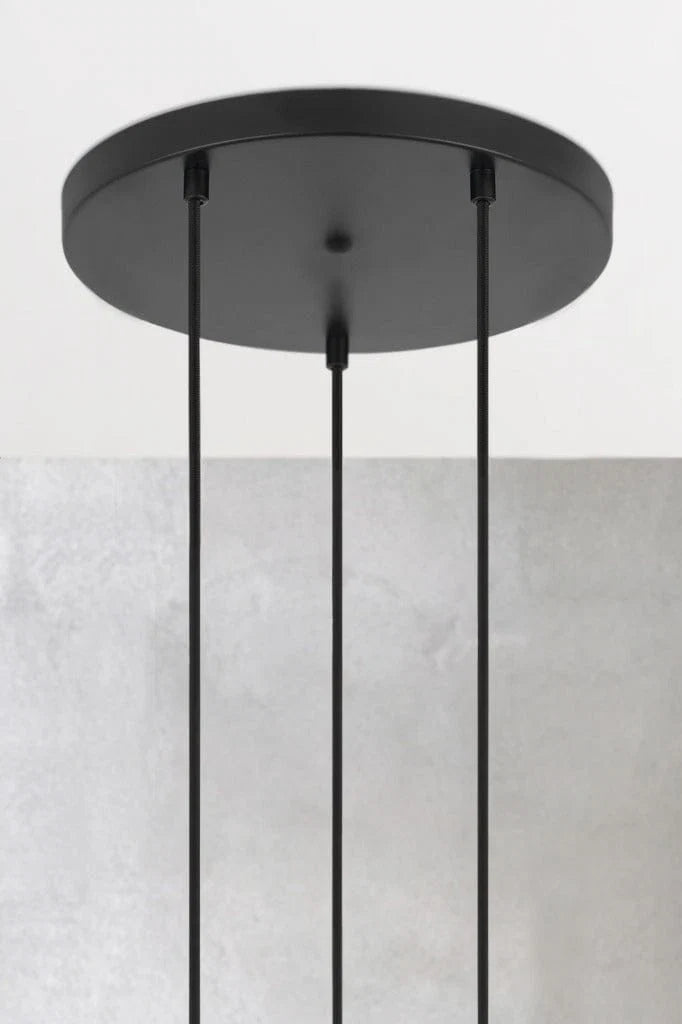 A modern black pendant light fixture with a circular ceiling canopy and three hanging cords that hold the shades