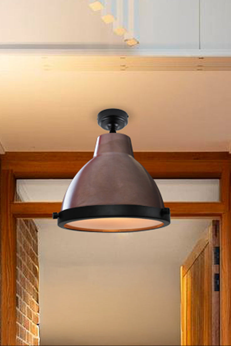Aged brass loft light with glass cover in an entry way. 