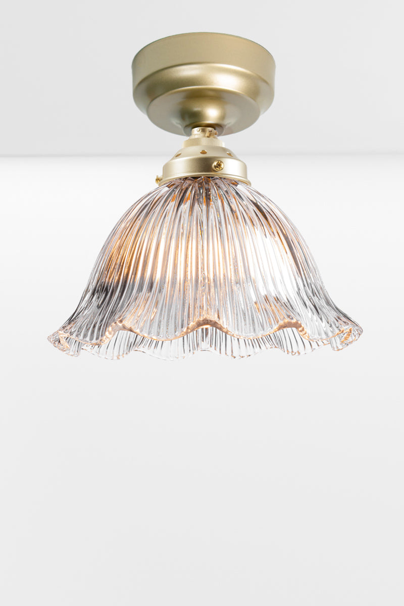 Holophane clear shade with a frilled edge paired with a gold/brass batten holder. 