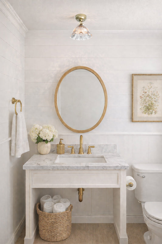 Large pleated clear glass shade with frilled edge detailing on a gold batten holder in a powder room. 