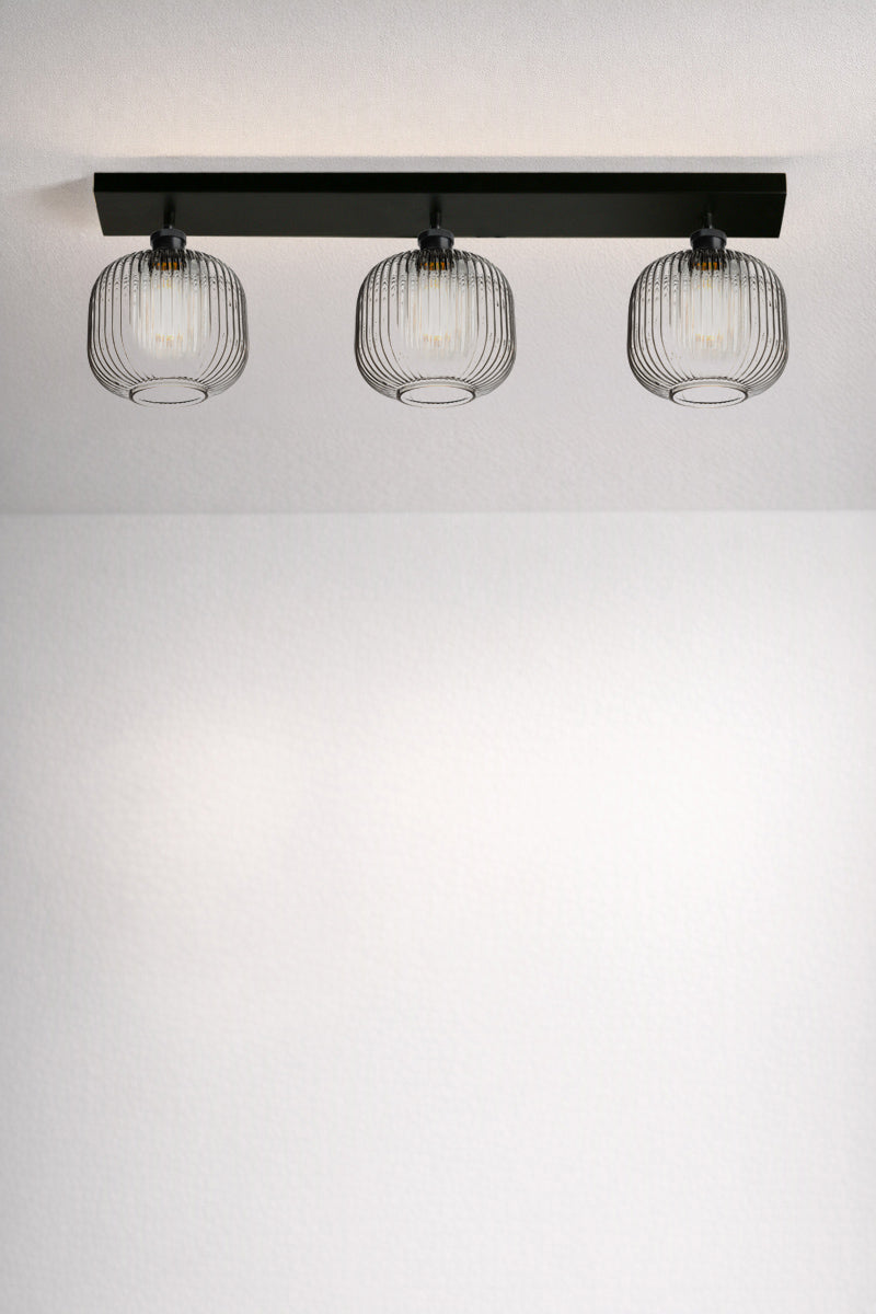 Balmain Reeded Glass 3 Light Flush Mount with clear glass shades shown illuminated