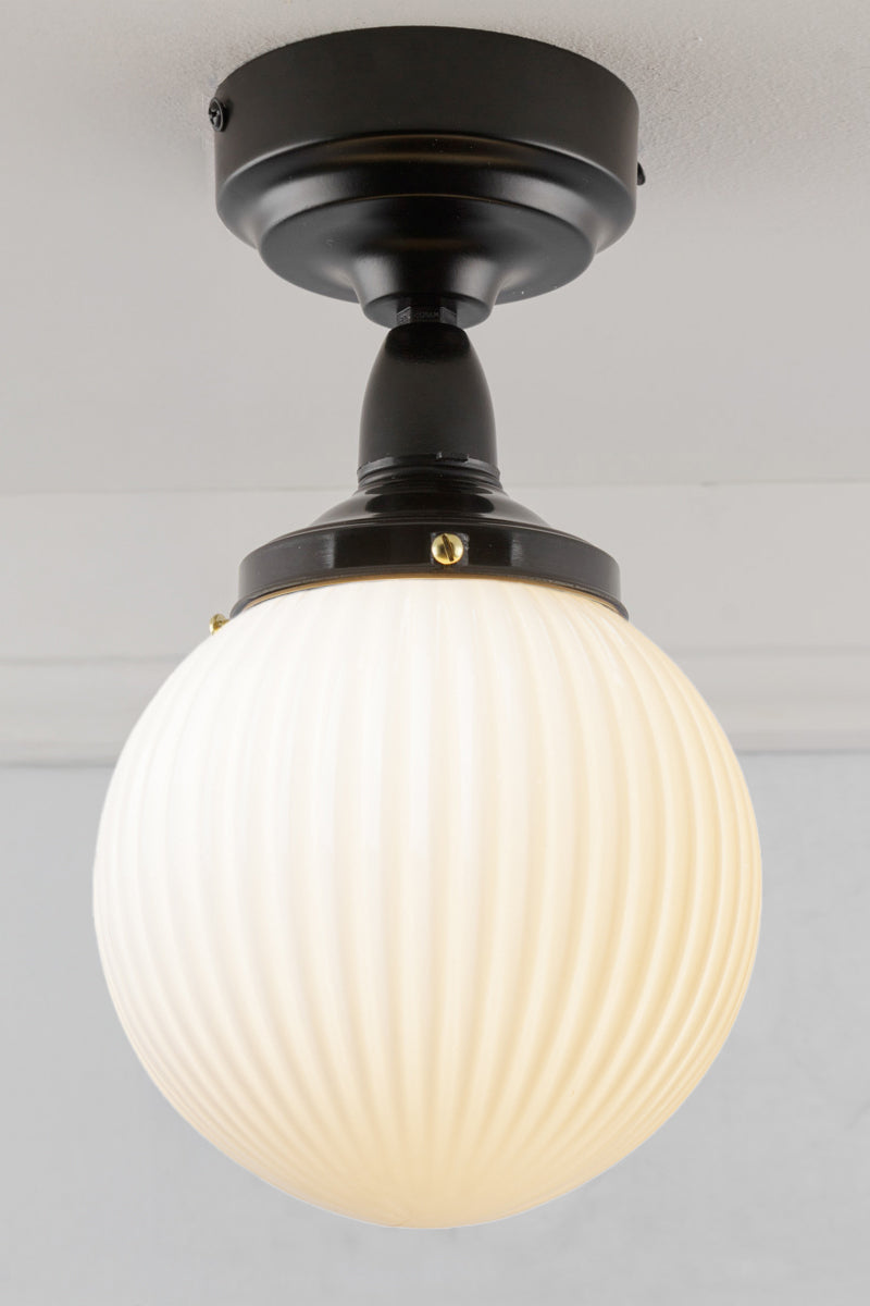 Opal glass ball shade with reeded detailing and black batten fixture. 