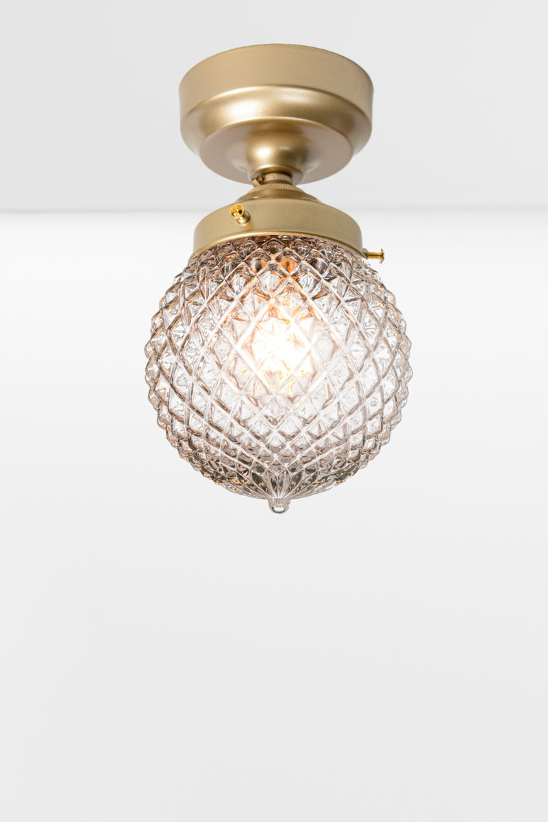 Clear glass ball shade with vintage detailing on a gold/brass batten holder. 