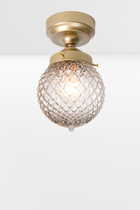 Clear glass ball shade with vintage detailing on a gold/brass batten holder. 