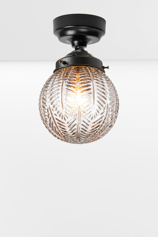 Clear glass orb shade with vintage inspired detailing on a black batten holder.