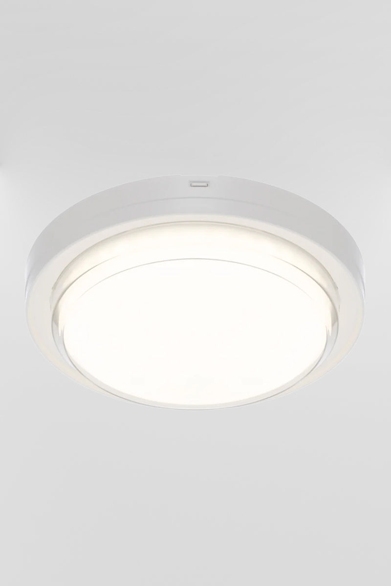 Round polycarbonate bunker light with white frame, with the LED light source turned on.