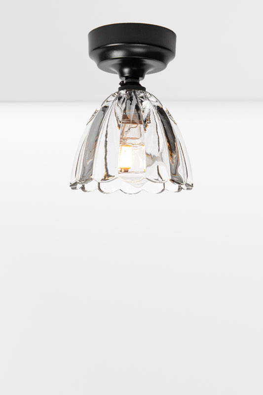 Clear glass shade with scalloped edging on a black batten holder. 