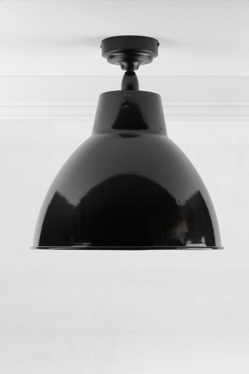Black outdoor flush mount light with a large steel shade finished in black. 