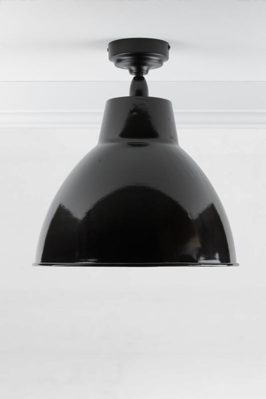 Black outdoor flush mount light with a large steel shade finished in black. 