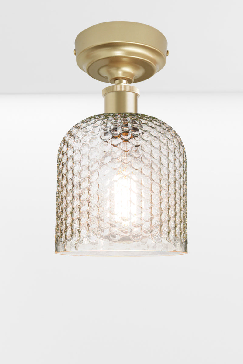 Clear dimpled glass shade with a gold/brass batten holder. 