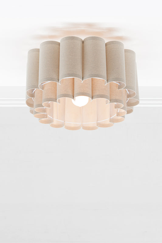 Neutral toned fabric shade with two teirs in a scallopped formation, paired with an opal bulb.