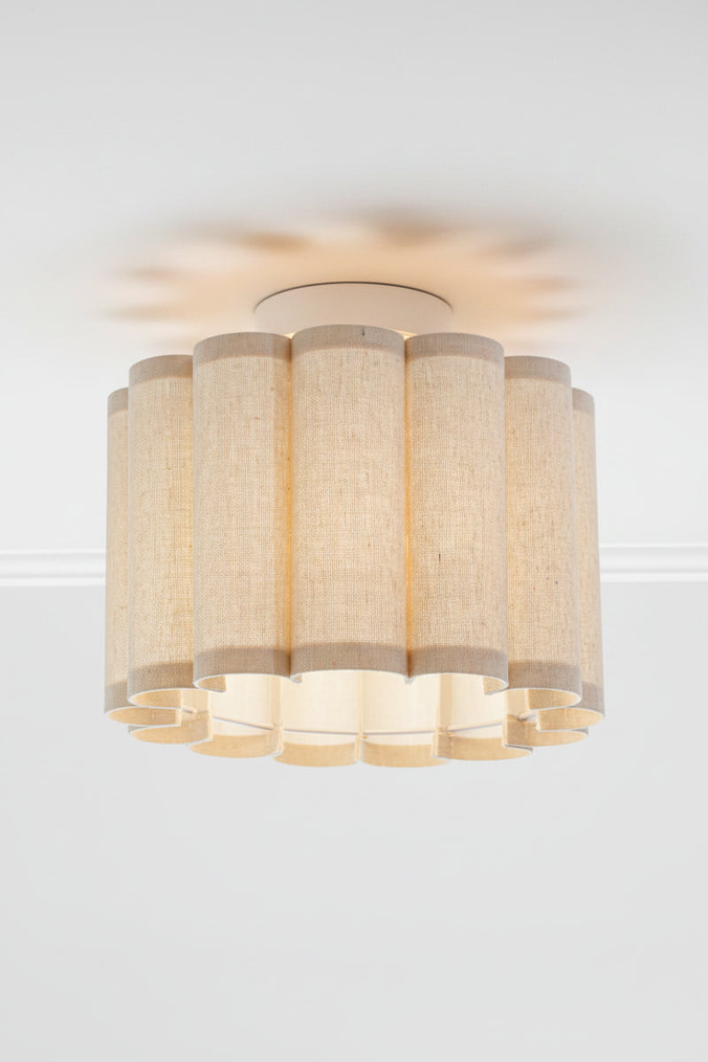 Ceiling ligh with a scalloped fabric shade on a white batten holder. 