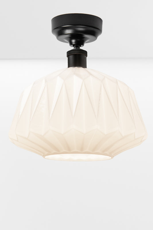 Large geometrically detailed opal shade paired with a black batten holder.