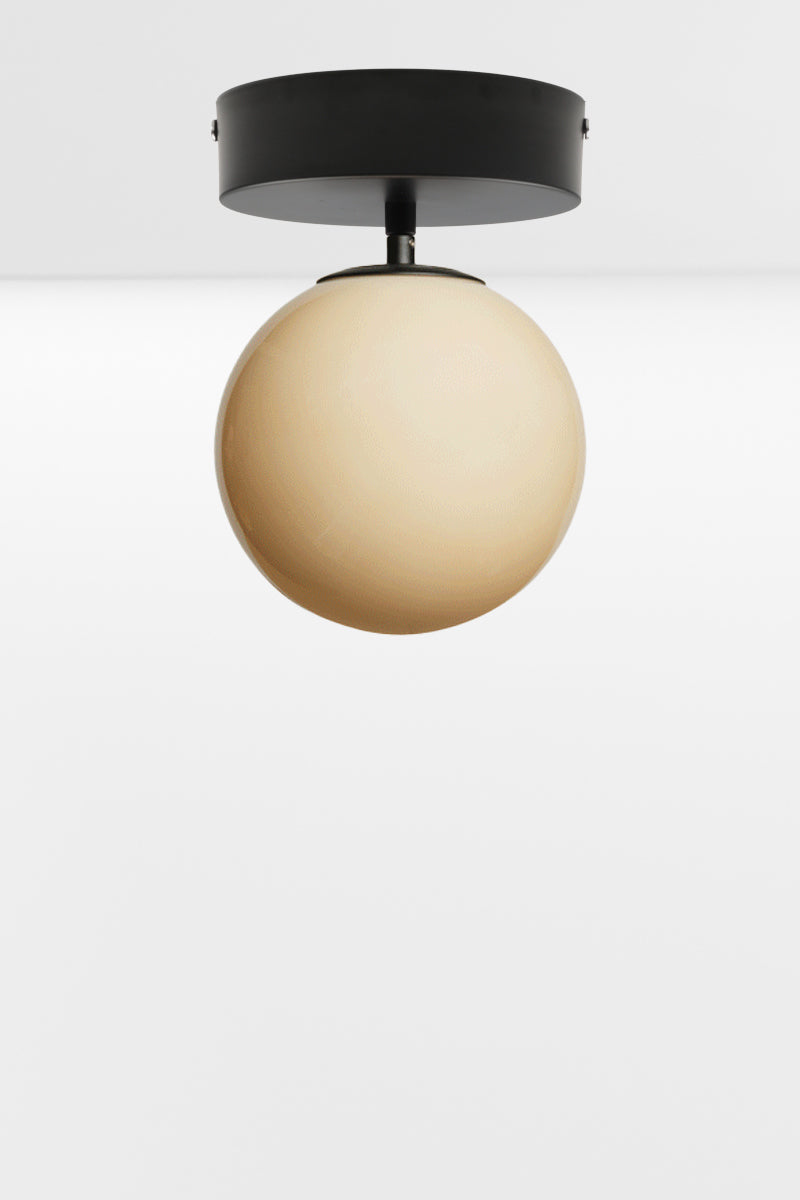 Amber glass orb shade on a black batten holder. 