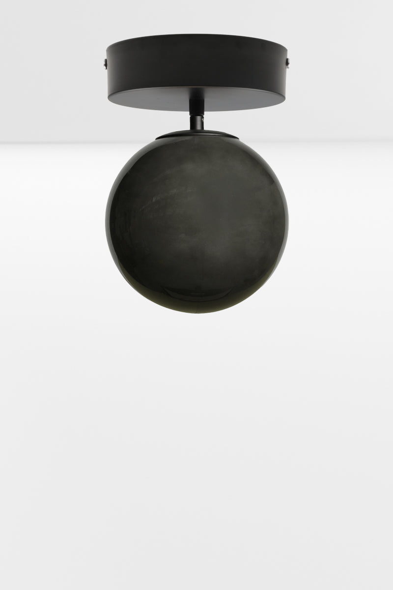 Dark grey glass orb shade on a black batten holder. 
