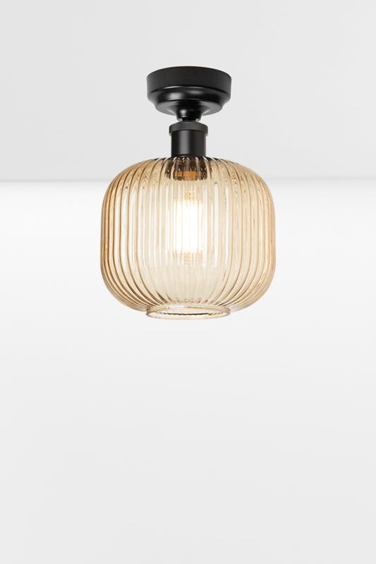 Amber reeded glass shade paired with a black batten holder. 