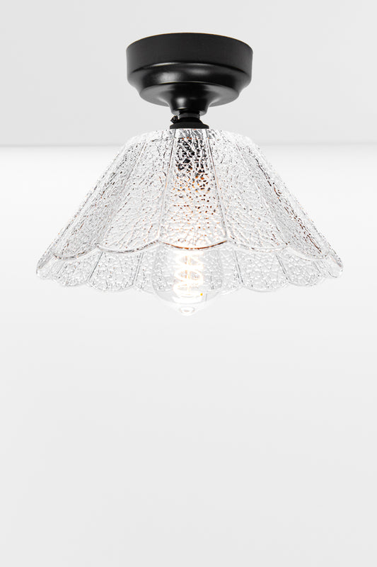 Clear glass shade with scalloped edging and a crackle effect paired with a a black curved batten holder an a clear tear drop bulb. 