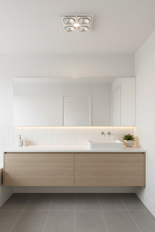 Midas Quattro 3-in-1 Bathroom Heater with Exhaust Fan and LED Light in white, in a modern bright white bathroom with light timber vanity cabinets. 