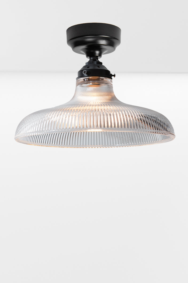 Large clear holophane glass shade on a black batten holder.