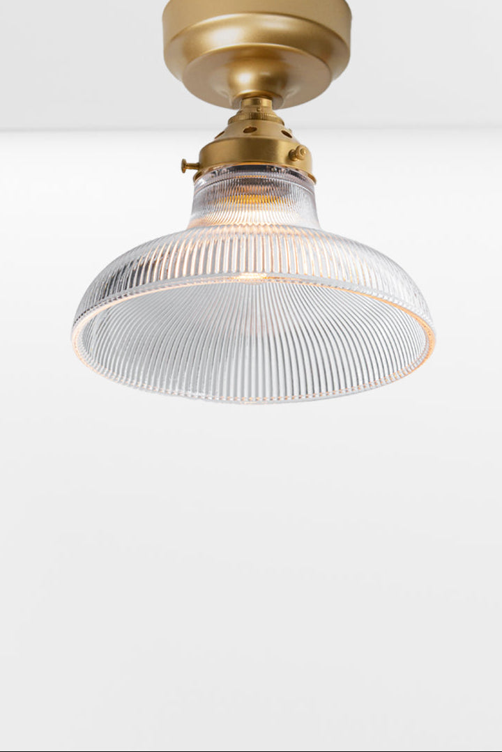 Small clear holophane glass shade on a gold/brass batten holder.