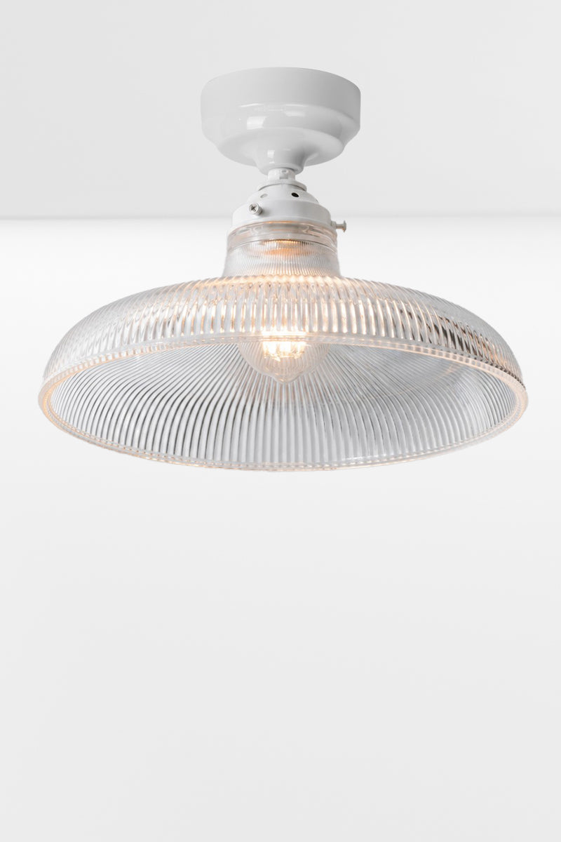 Large clear holophane glass shade on a white batten holder.