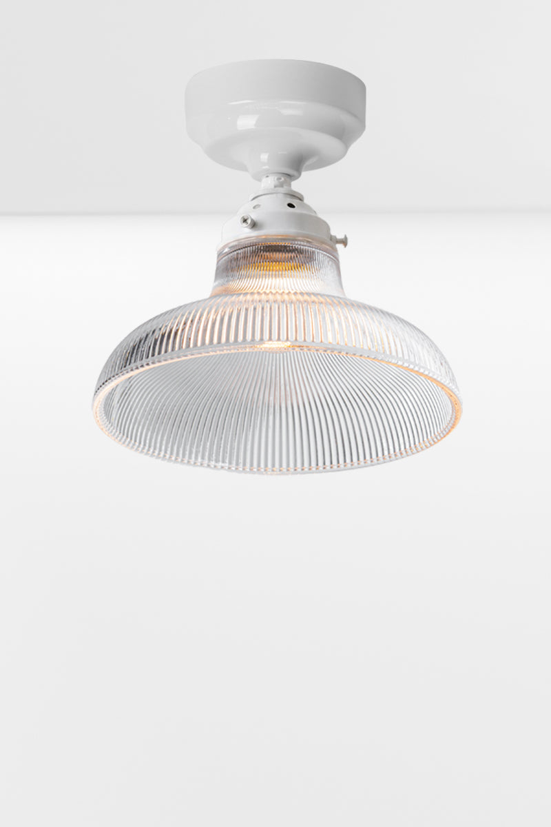 Small clear holophane glass shade on a white batten holder.