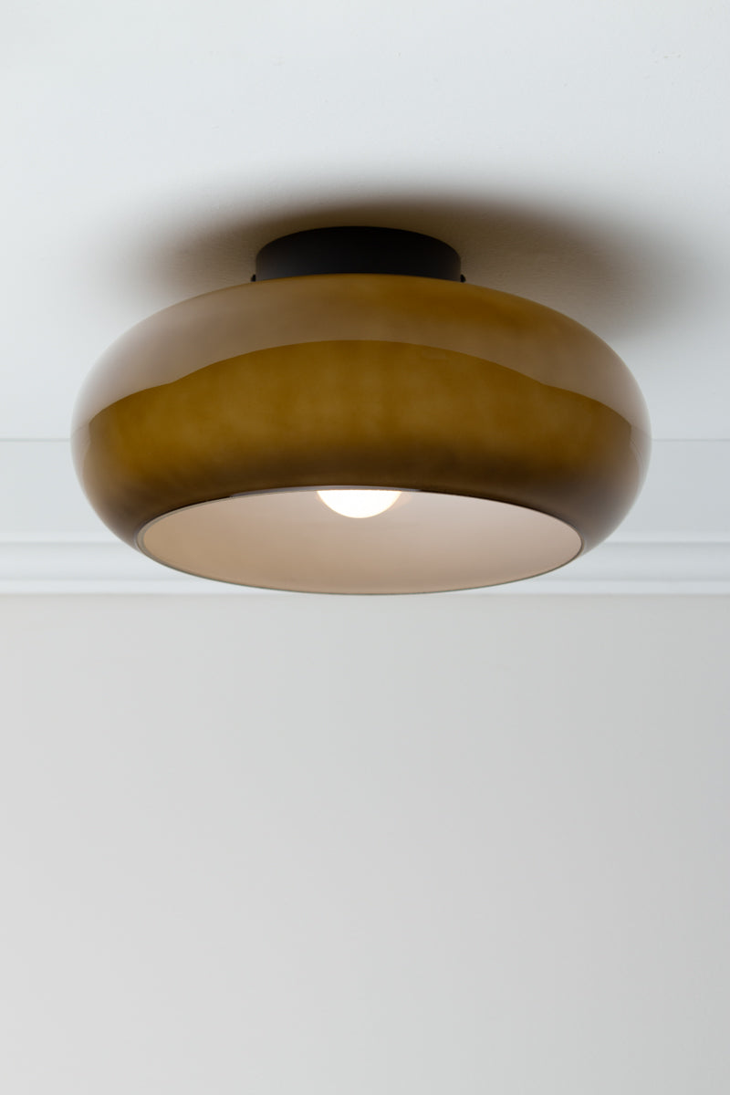 Sage green Avoca Glass Ceiling Light illuminated, showing rounded glass shade and white interior.