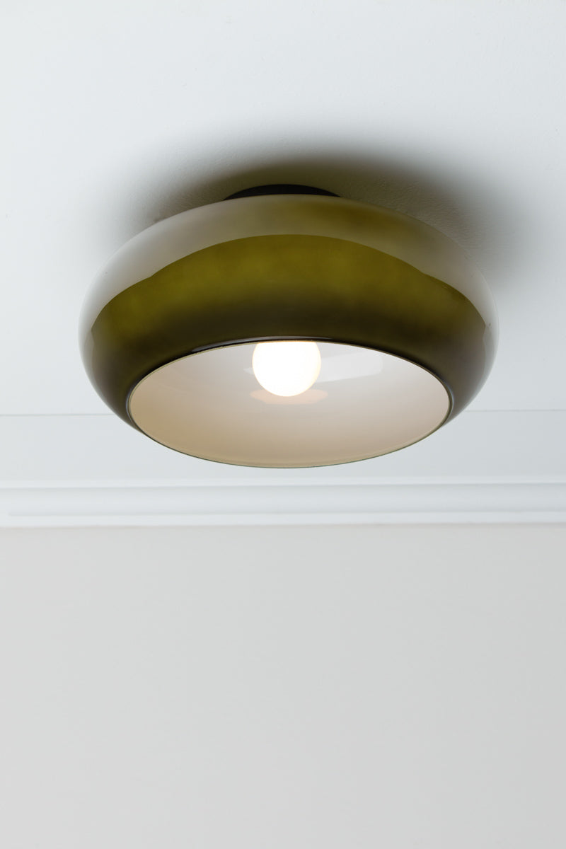 Forest green Avoca Glass Ceiling Light illuminated from below with glossy glass shade and white interior.