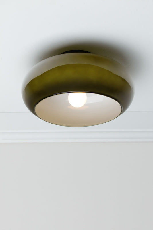 Forest green Avoca Glass Ceiling Light illuminated from below with glossy glass shade and white interior.