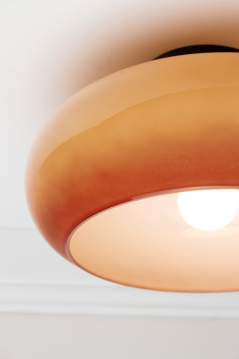 Close-up of illuminated brown Avoca Glass Ceiling Light showing tonal glass shade and white interior.