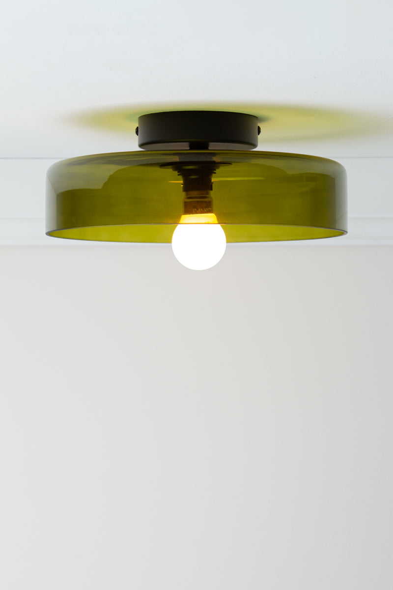 Valla Glass Ceiling Light with broad transparent green glass shade, black batten holder and exposed globe.