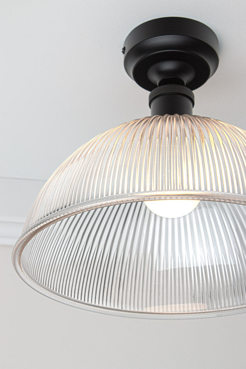 Close-up of Garda Glass Ceiling Light with clear ribbed glass dome shade and black ceiling fixture