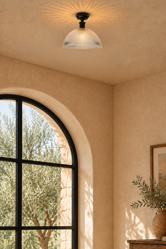 Clear glass dome shade attached to a black batten holder in a Mediterranean light filled hallway. 