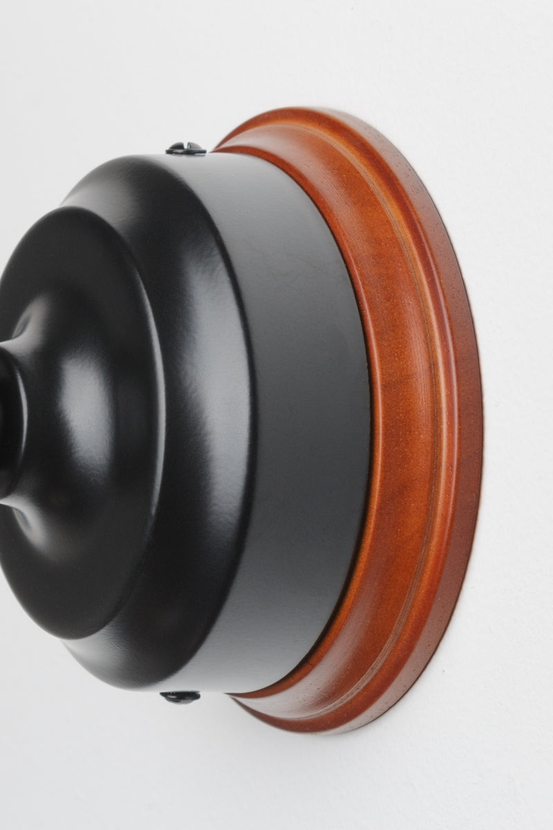 Black wall sconce with natral finished wood mounting block.