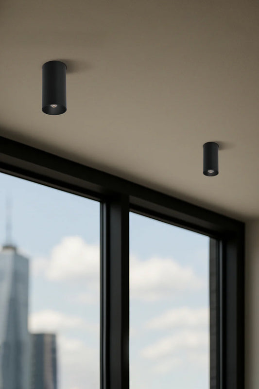 Two grey umbra finishes pin style surface mounted LED downlights on a textured white ceiling. 