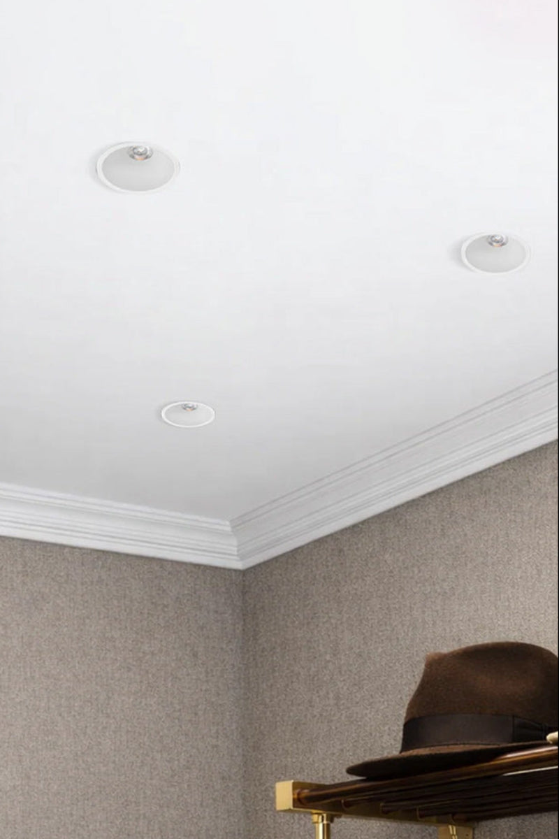 Four white LED downlights in the ceiling of a dressing room. 